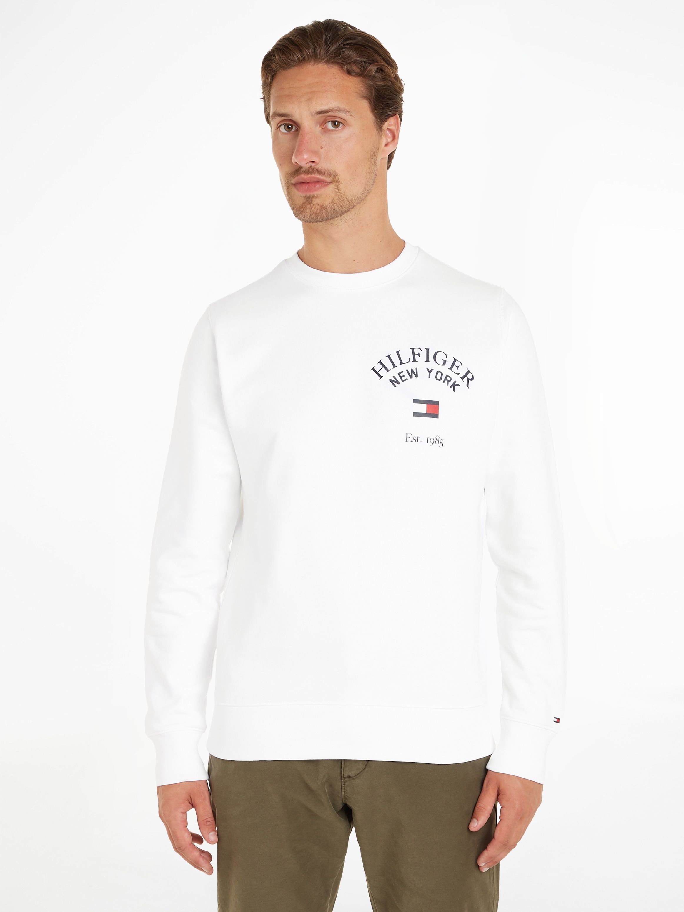 Tommy Hilfiger Sweatshirt »WCC VARSITY SWEATSHIRT«, BAUR Brust modischem der ▷ ARCHED mit bestellen Logodruck | auf