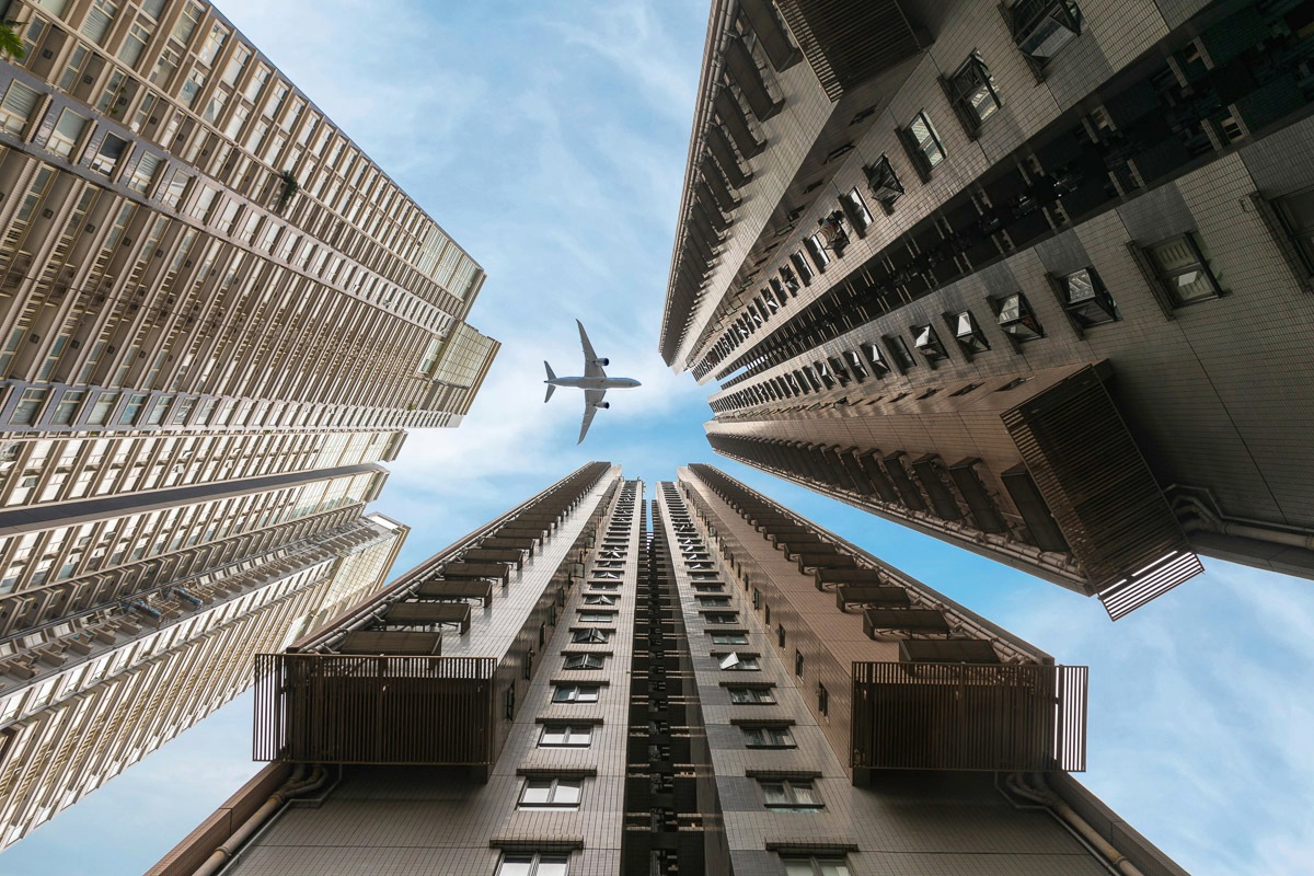 Papermoon Fototapete »Flugzeug über Häusern«