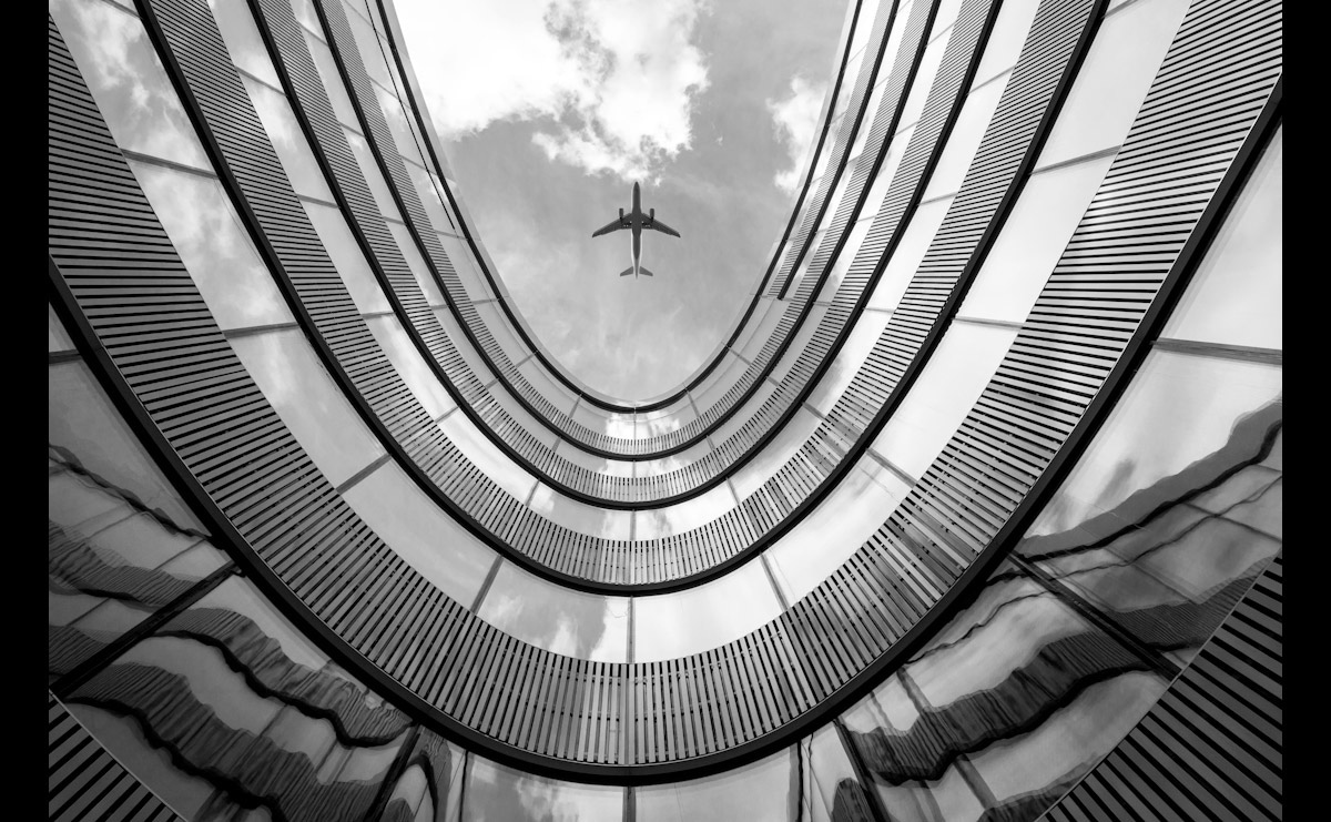 Papermoon Fototapete »Flugzeug über Gebäude«