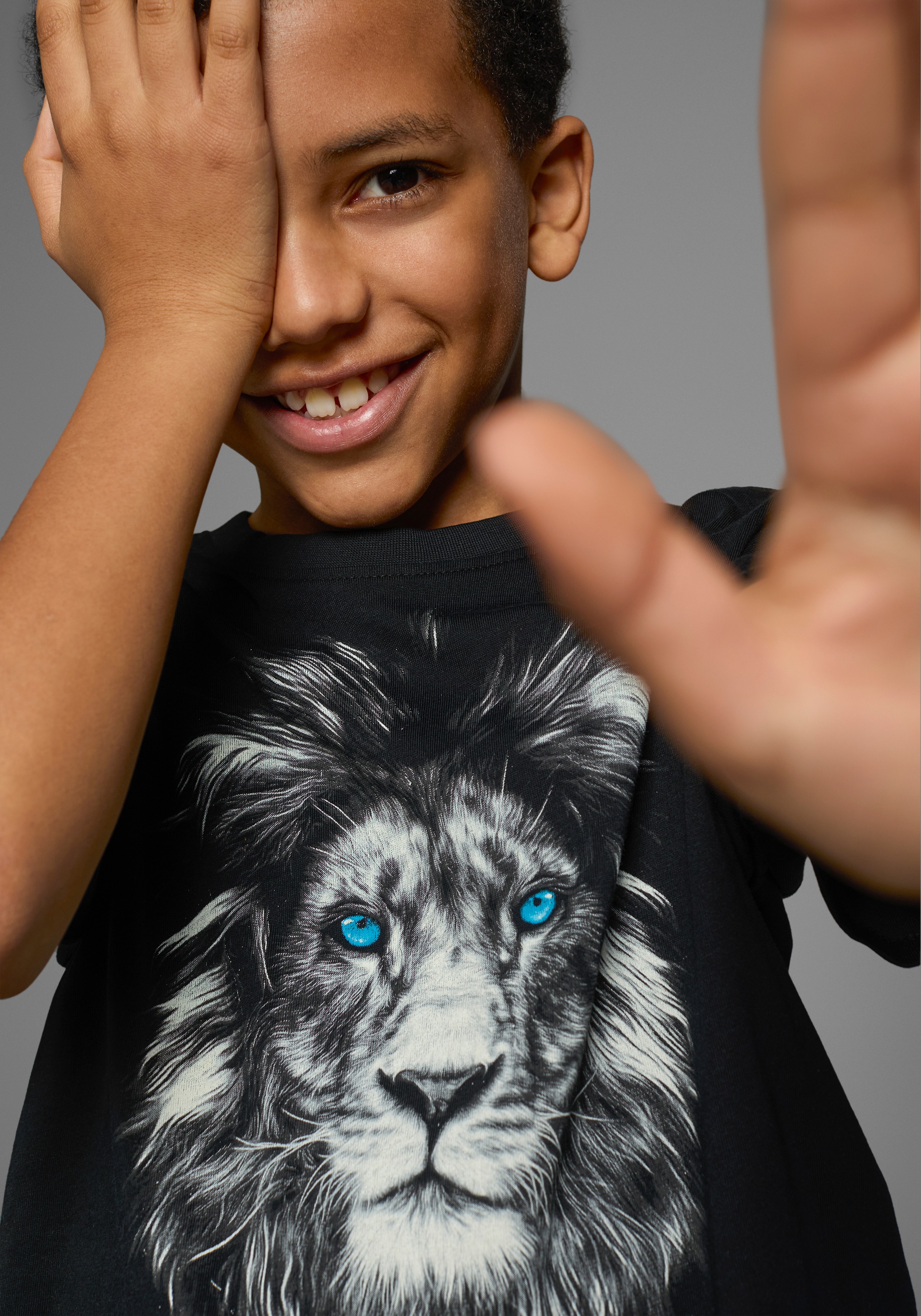 Thumbnail - KIDSWORLD T-Shirt "Mit Löwenprint: LION WITH BLUE EYES" Kurzarm, Basic-Passform, mit trendigem Druck, Rundhalsausschnitt