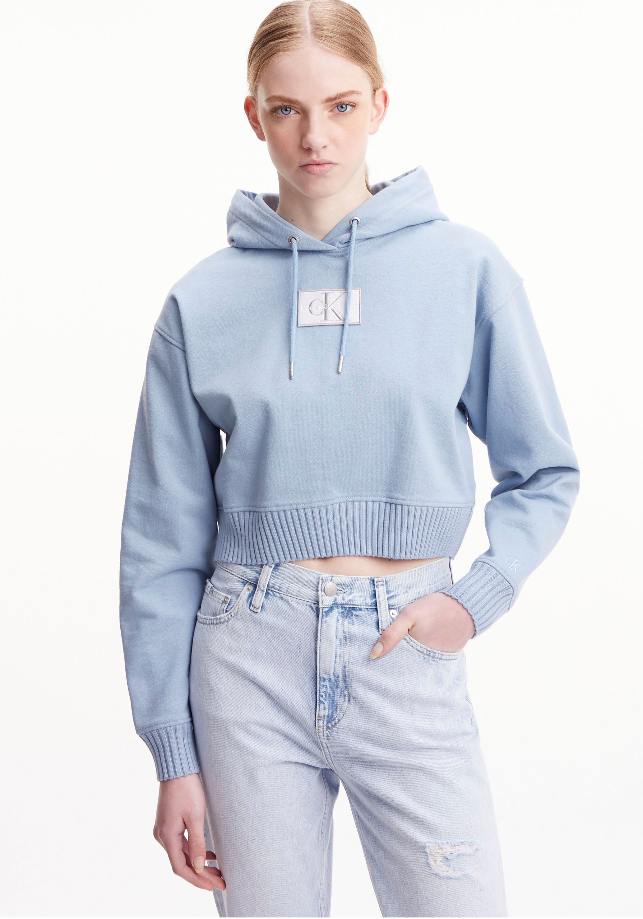 Calvin Klein Jeans Kapuzensweatshirt »BADGE WIDE SLEEVES CROP HOODIE« mit Calvin Klein Markenlogo auf der Brust