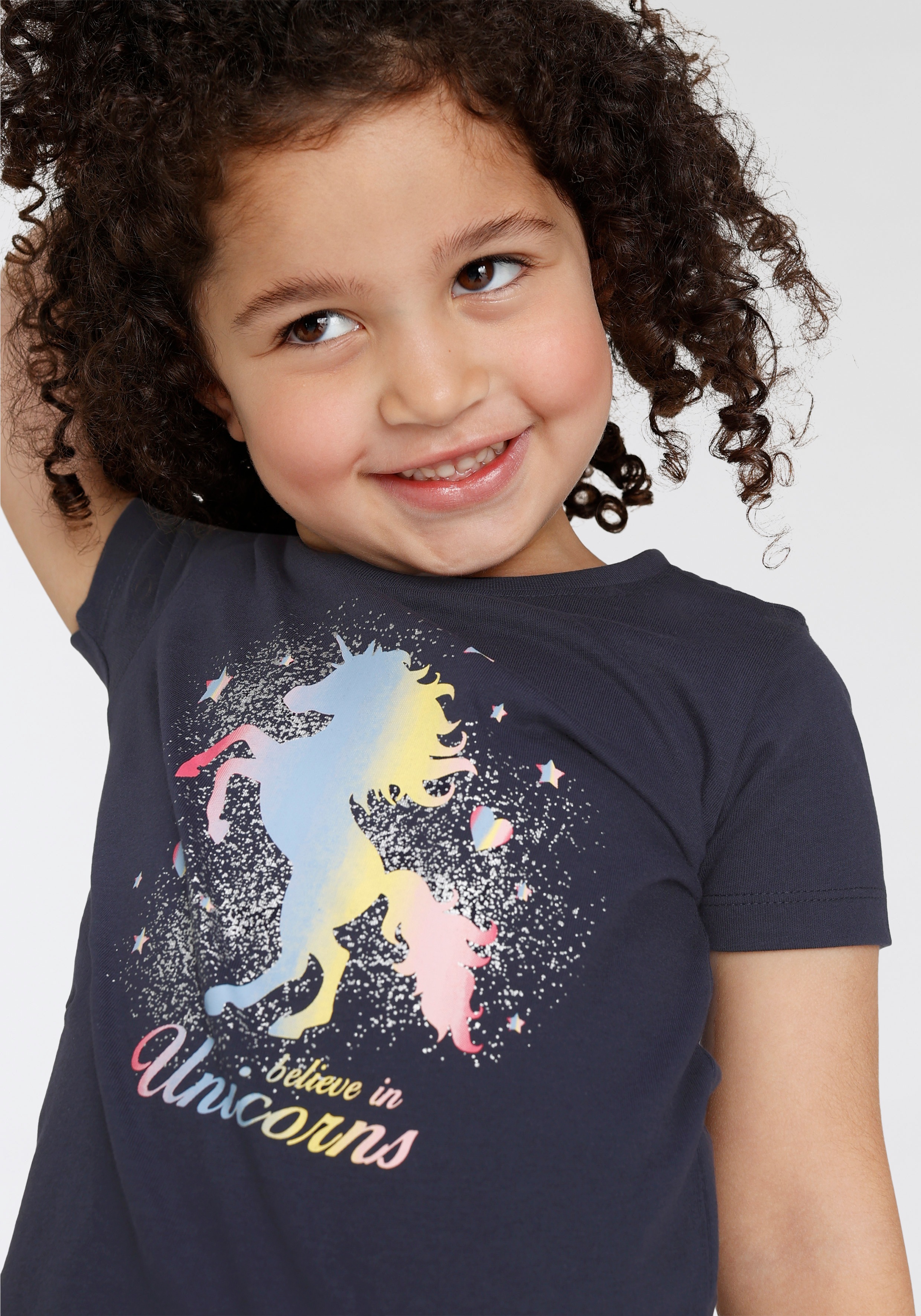 Thumbnail - KIDSWORLD T-Shirt "believe in Unicorns" Kurzarm, hüftlange Passform, mit Glitzerdruck, Rundhalsausschnitt