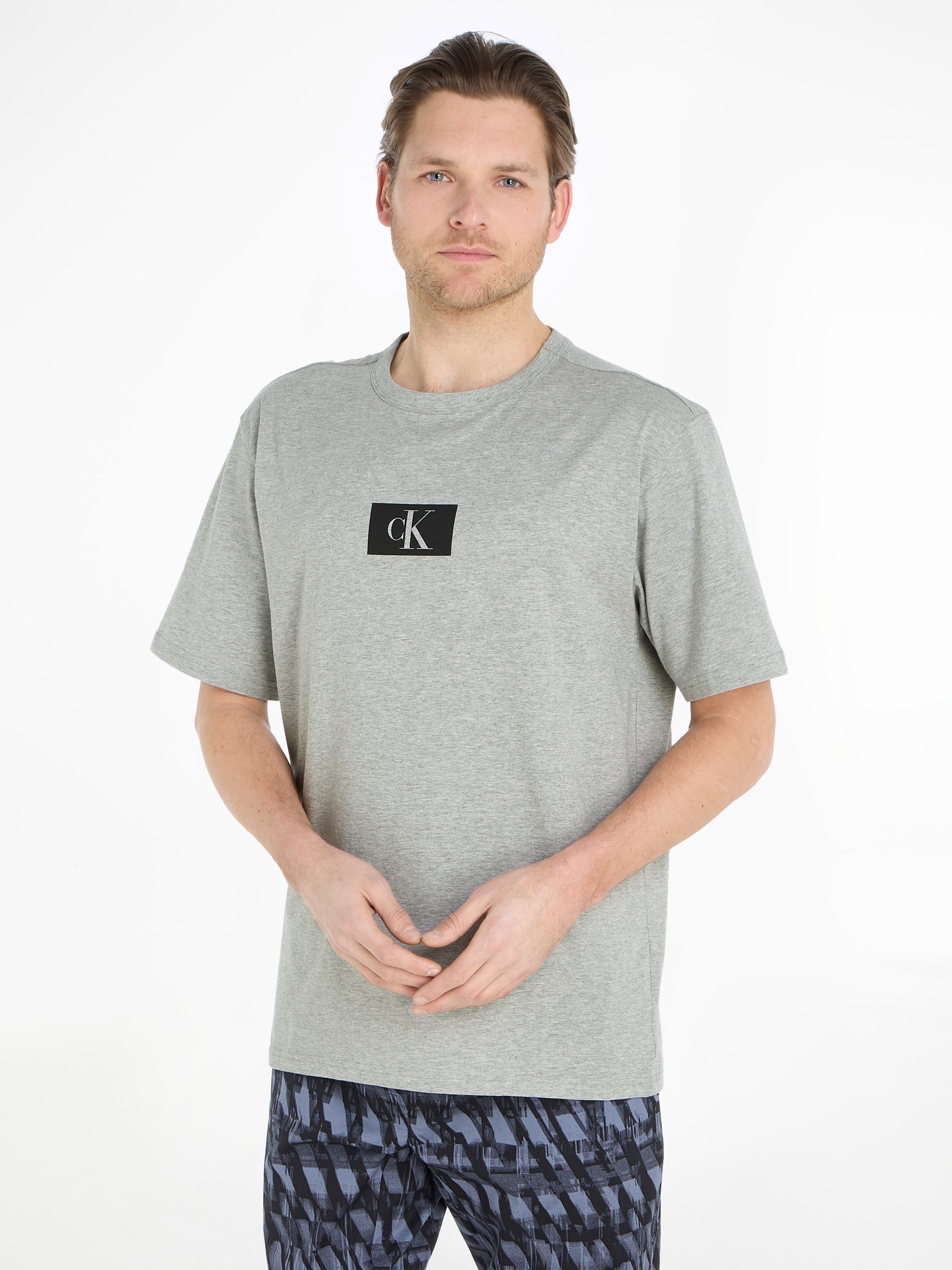 Calvin Klein T-Shirt BAUR | auf bestellen CREW Brust mit ▷ der »S/S Logodruck NECK«