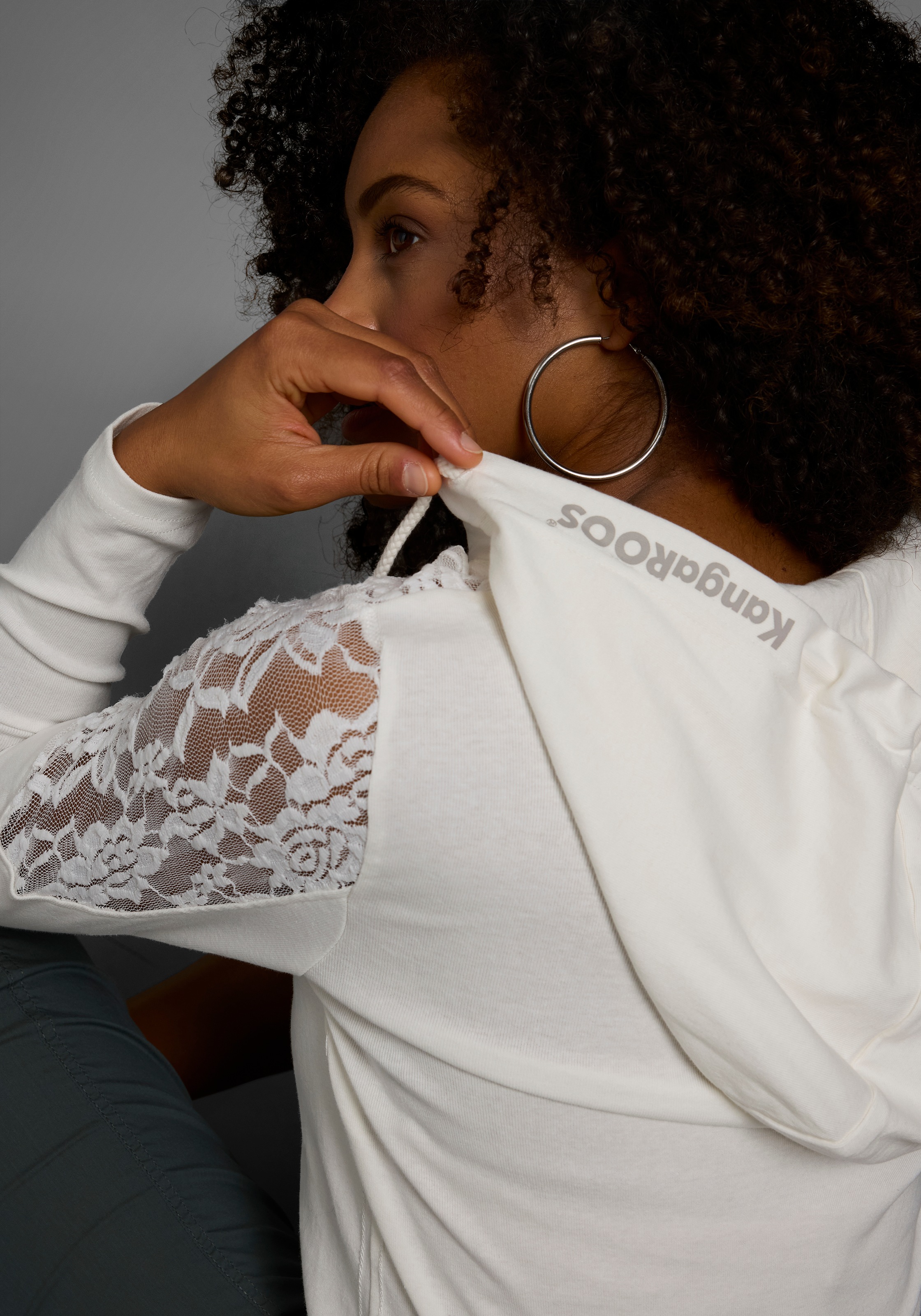 Thumbnail - KangaROOS Kapuzenshirt Langarm, figurbetonter Schnitt, mit Spitze und Print, aus Baumwolle