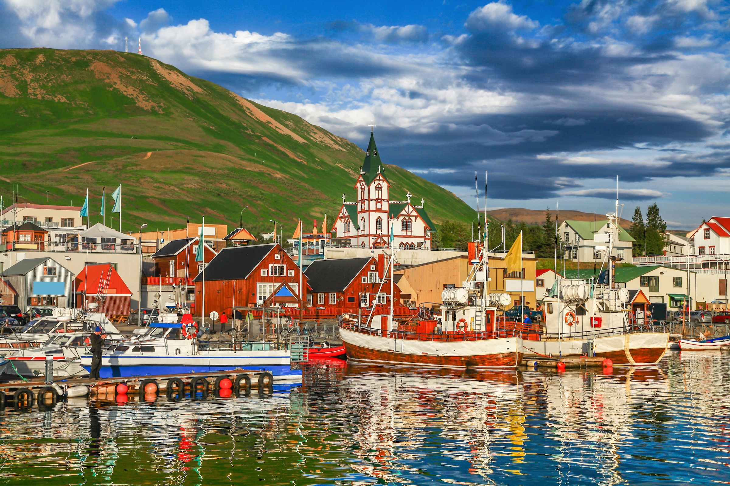 Fototapete »HUSAVIK ISLAND-BOOTE GEBIRGE DORF STEG BRÜCKE WALD BERG«